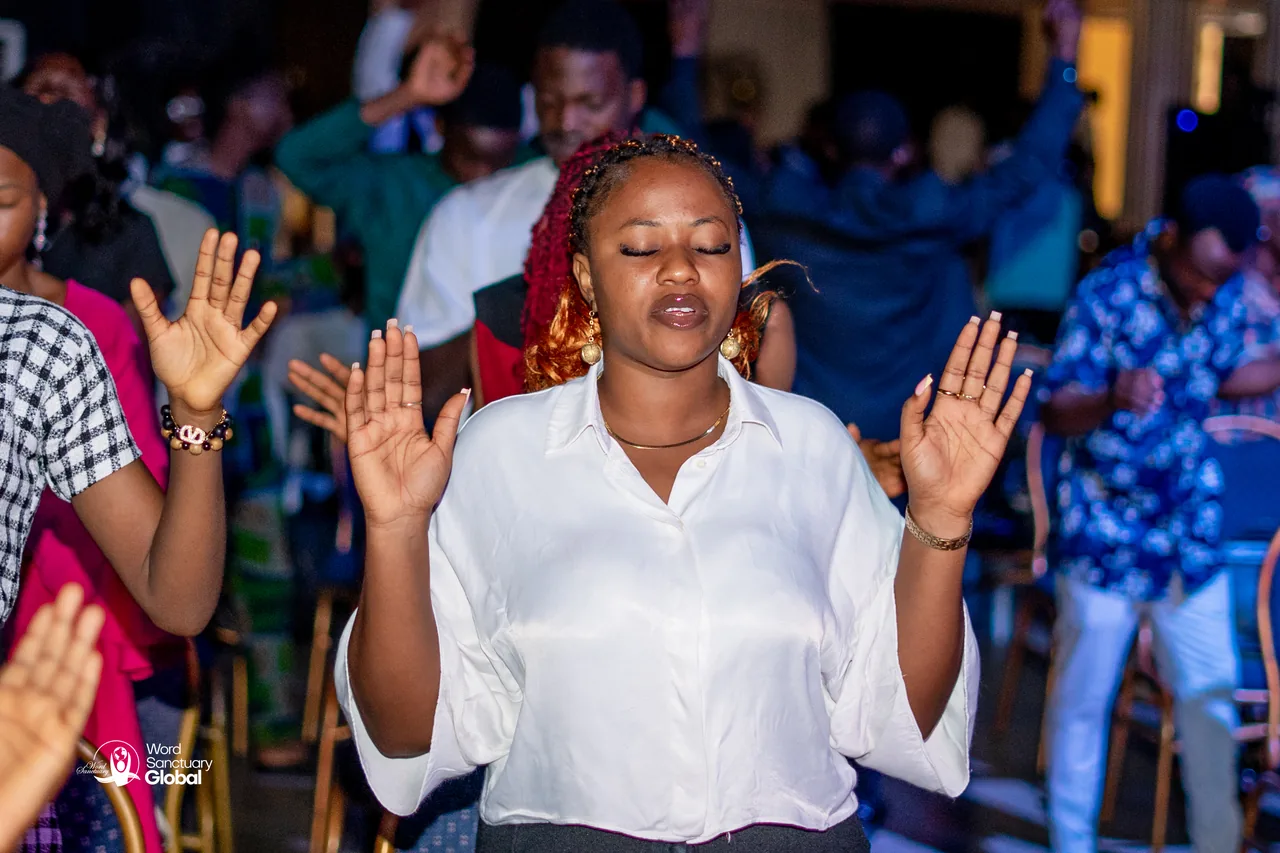 A worshipper with arms raised during service